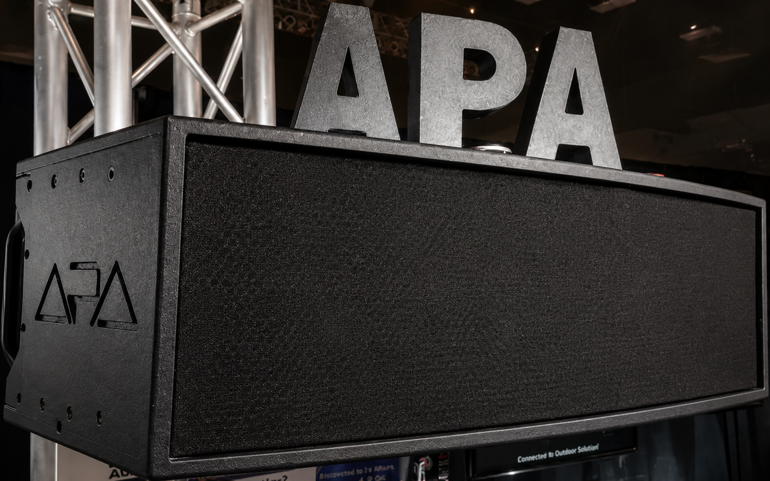 Ethan 8 main and surround speaker — a compact matte-black cabinet mounted flat against a wall.
